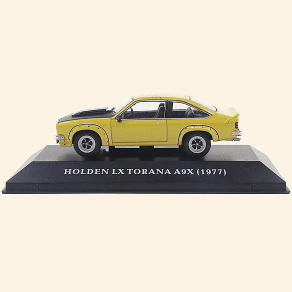 a yellow toy car on a black base